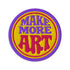 A round embroidered patch with the words "MAKE MORE ART" in a retro 70s psychedelic font. The word "ART" is magenta pink, "MAKE MORE" is purple, and they are set against a bright yellow circular background. The entire design is encircled by a thin pink line and a thick purple border. This 3-inch iron-on applique is a colorful, groovy accessory for DIY projects, perfect for personalizing jackets, backpacks, or denim vests. It serves as an inspirational artist gift with a vintage aesthetic.