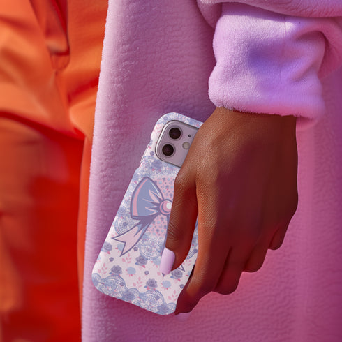 Coquette phone case featuring a pastel purple bow and pink floral lace background, dual-layer protection, UV protected, compatible with iPhone, Samsung Galaxy, and Google Pixel.