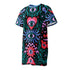 A short-sleeve, above-the-knee t-shirt dress with a true black background. The front features a vibrant, vertically stacked symmetrical graphic design. From top to bottom, the design includes a pink heart containing a green and blue eye, a large blue sunburst with a central eye, a red daisy flower with an eye flanked by pink and black checkered arches, and a pink mushroom cap with an eye. Swirling emerald green foliage, pink stars, and purple stars fill the negative space around the motifs.