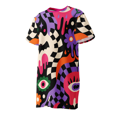 A short-sleeve, above-the-knee t-shirt dress with a relaxed, straight fit and a crew neckline. The dress features a vibrant, chaotic, all-over graphic print. The design includes sections of distorted, wavy black and cream checkerboard, mixed with bold, abstract shapes in bright purple, hot pink, and vivid orange. Scattered throughout the pattern are motifs of hot pink dripping slime, a black bat silhouette, a stylized green eye with a pink iris, and retro pink and purple daisy flowers.