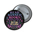 Glossy black pinback button that says “Read Banned Books” in purple and teal letters, featuring a chained book, roses, bows, and floral accents, styled on colorful books and pastel backgrounds.