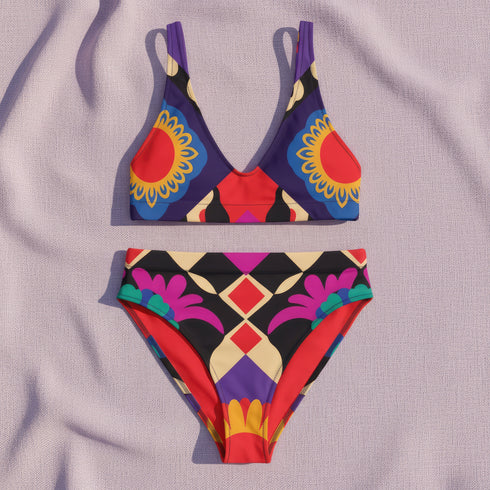 Two piece high waisted bikini in a bold 70s psychedelic geometric print. The sporty scoop top features bright yellow and red sunbursts over a black, purple, cream, and red colorblock background. The high cut bottoms carry matching geometric diamonds with hot pink and teal abstract palm leaves. Smooth form fitting recycled polyester fabric with UPF 50 sun protection and removable padding. Vibrant maximalist retro swimwear in saturated primary and secondary shades, made for pool parties, festivals, and loud s