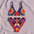 Two piece high waisted bikini in a bold 70s psychedelic geometric print. The sporty scoop top features bright yellow and red sunbursts over a black, purple, cream, and red colorblock background. The high cut bottoms carry matching geometric diamonds with hot pink and teal abstract palm leaves. Smooth form fitting recycled polyester fabric with UPF 50 sun protection and removable padding. Vibrant maximalist retro swimwear in saturated primary and secondary shades, made for pool parties, festivals, and loud s