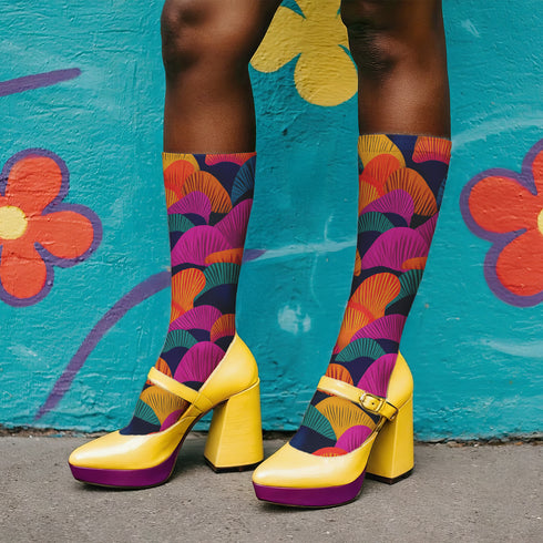 Colorful crew socks featuring a bold, fan-shaped mushroom pattern in orange, magenta, teal, yellow, and purple on a deep navy background. The design is vibrant and psychedelic, perfect for statement-making fashion. The socks are mid-calf length with reinforced heel and toe, made from a stretchy polyester, nylon, and spandex blend for comfort and durability.