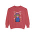 A holiday sweatshirt featuring a cute Grim Reaper holding a scythe, wearing a Santa hat. Above the character is the text "Grave Tidings We Bring," surrounded by festive snowflakes and holiday-themed designs. The combination of spooky and festive elements adds a humorous twist to traditional holiday attire.