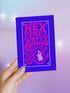 A vertical 5x7 greeting card made from premium 120lb silk cover stock with a slight sheen. The card has a deep purple background with a thin pink border. In the center, the words 'Hex the Halls' are written in a bubbly, psychedelic 70s-style font in shades of hot pink and light pink. Below the text is a stylized pink silhouette of a woman's face in profile with long, flowing, wavy hair. The design is reminiscent of retro witchcraft and groovy aesthetics, perfect for an alternative holiday.