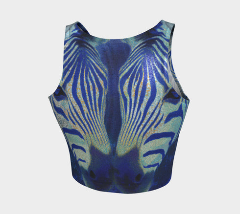 A women's sleeveless, high-neck crop top made from a performance spandex knit fabric. The top is designed with a body-hugging fit and features a striking, symmetrical digital graphic of a zebra's face. The intricate print uses shades of electric blue, cobalt, and navy, contrasted with a shimmering silver glitter effect that outlines the zebra's stripes and features. The psychedelic, futuristic design covers the entire front of the shirt.