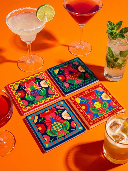 A set of four square coasters featuring a glossy glazed finish and vibrant insect illustrations. Each coaster measures approximately four by four inches. The designs showcase symmetrical beetles and spiders in bold red, blue, and orange colors, framed by intricate floral and geometric borders in a maximalist folk art style. Available in ceramic with cork backing or hardboard MDF. The edges are smooth. The designs are vivid and highly saturated, designed to provide grip and protect furniture.