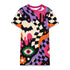 A short-sleeve, above-the-knee t-shirt dress with a relaxed, straight fit and a crew neckline. The dress features a vibrant, chaotic, all-over graphic print. The design includes sections of distorted, wavy black and cream checkerboard, mixed with bold, abstract shapes in bright purple, hot pink, and vivid orange. Scattered throughout the pattern are motifs of hot pink dripping slime, a black bat silhouette, a stylized green eye with a pink iris, and retro pink and purple daisy flowers.