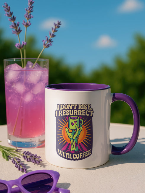 White ceramic coffee mug with red handle and interior, featuring a bold design of a zombie hand holding a coffee cup with the text “I Don’t Rise, I Resurrect With Coffee” in white and purple, accented with a neon green hand and orange sunburst background.