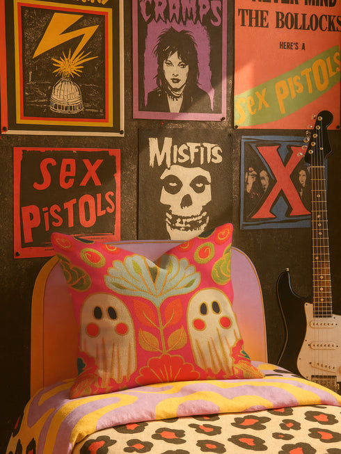 a bedroom with a bed, a guitar, and various posters on the wall.
