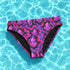 High-waisted bikini bottom with a psychedelic crystal pattern in purple, magenta, and black, featuring cheeky cut and four-way stretch fabric with a moisture-wicking finish.