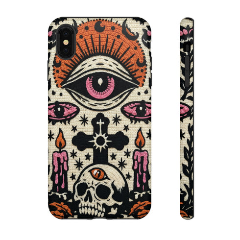 A vertical phone case design featuring a faux crochet texture illusion printed on a cream background. The symmetrical pattern centers on a large black eye with a pink iris and rust-orange sunburst lashes at the top. Below the eye is a black cross surrounded by small black stars. The bottom features a skull with a third rust-orange eye on its forehead. Flanking the skull are two candles with orange flames and rust-colored leaves. The design mimics the look of stitched yarn but is a 2d print.