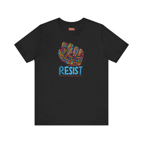Black t-shirt with vibrant multicolored patterned raised fist graphic and blue "RESIST" text underneath. Rainbow activist protest shirt with psychedelic design elements on cotton-polyester blend.