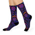 Mid-calf socks with a dark violet-black base featuring a gothic dagger and rose design in gradient shades of red, purple, and pink, with black heels and toes and an illustrated snake detail.