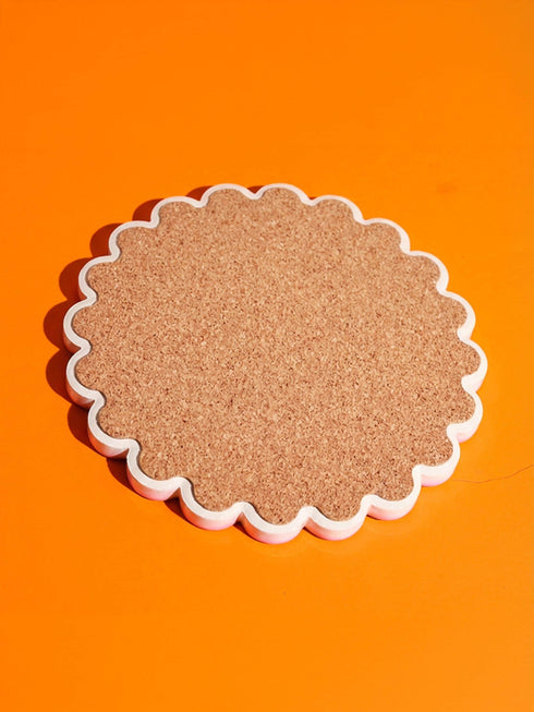 Round ceramic coaster with scalloped edges featuring a vibrant pop art design of an open mouth with green lips and a red tongue sticking out. The background is a bright red with psychedelic floral swirls in yellow orange and green. The surface is glossy glazed ceramic. The back is made of cork to prevent slipping. This maximalist decor piece fits retro 70s funky and weirdcore aesthetics. It is a bold statement piece for coffee tables. The design is colorful and eclectic dopamine decor.