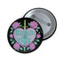 Glossy black pinback button featuring embroidered-style artwork of a pastel purple heart that reads “Read or Die” pierced by a sword and surrounded by roses; shown on books, graffiti, and lace backgrounds.