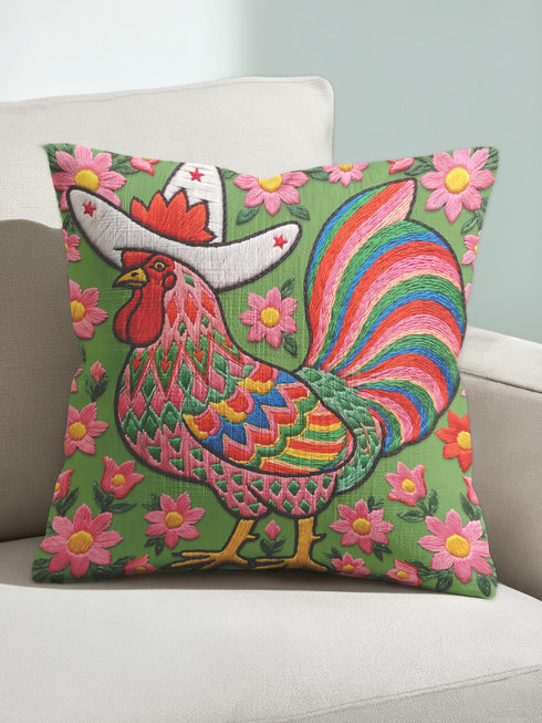 Square throw pillow cover with a printed faux embroidery design of a rooster wearing a white cowboy hat with red stars on a grass green background. The western chicken has a red comb and wattle, yellow beak and feet, and layered feathers in pink, green, orange, blue, and yellow with a rainbow striped tail. Pink and red flowers with yellow centers frame the bird. The stitched look is a flat 2D print on a smooth linen feel polyester cover with a hidden zipper, not raised embroidery.
