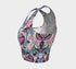 A sleeveless cropped tank top made from stretchy performance knit fabric. The all-over print features a dense, scattered pattern of pastel goth and creepy cute motifs over a light background. Graphics include pink and blue bats in flight, floating eyeballs with blue irises, pink skulls, and glossy vampire lips with sharp white fangs and tongues sticking out. The neckline is a high scoop and the armholes are curved. The fabric comes in either a matte finish or a sparkly silver glitter foil.