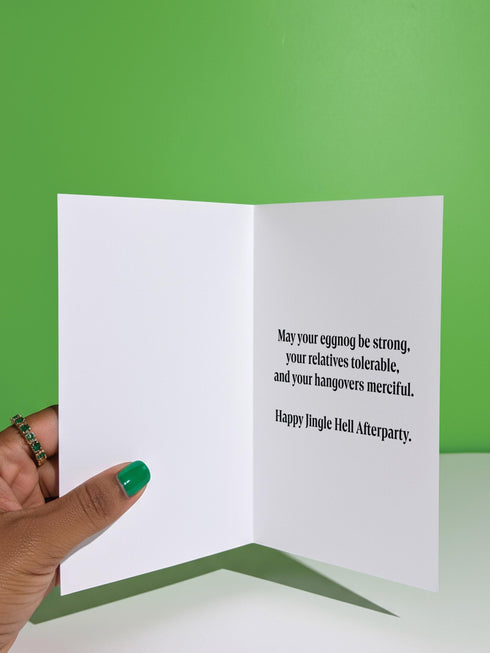 A 5x7 pearlescent shimmer folded greeting card featuring the Jingle Hell Survivors Club design. The front is a illustration of a grumpy red devil imp character, wearing a small Santa hat, holding a coffee cup, and a circular 'I Tried' merit badge. The overall aesthetic is maximalist dark humor and spooky cute. This anti-Christmas card is perfect for those needing relief from holiday stress. Inside text references surviving tolerable relatives, strong eggnog, and merciful hangovers.