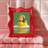 A fine art print of a rubber duck inspired by Marley, featuring black dreadlocks and a red-yellow-green beanie. The duck floats in bath bubbles with its reflection in green-tinted water. Displayed in a white and red frame on a soap-covered shelf in a bold red tile bathroom with a lightning-bolt soap dispenser.