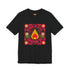 A high-resolution product image of a black unisex t-shirt featuring the ‘BURN IT ALL DOWN’ design in a folk-art style. The central motif is a vibrant orange and yellow flame surrounded by a circular medallion and a square floral border with red and pink flowers, white daisies, and green leaves. The print uses a faux-embroidery technique to create a trompe-l’œil 3D texture on a smooth 2D surface. The shirt has a ribbed knit collar, set against a high-contrast background.