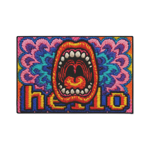 A rectangular indoor and outdoor doormat featuring a vibrant, psychedelic design. The central graphic is a large, open screaming red and orange mouth with white teeth, surrounded by highly saturated wavy, trippy patterns in blue, purple, magenta, and teal. Yellow stylized text reading HELLO is integrated into the pattern. The mat has a smooth 2D flat print surface that mimics the look of textured chainstitch embroidery, finished with a solid black fabric trim around all four outer edges.