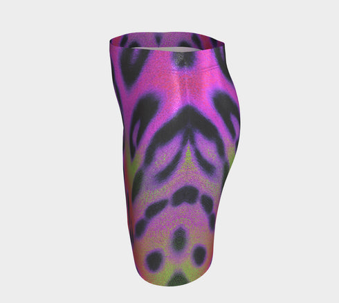 A high-waisted, bodycon mini skirt with a vibrant psychedelic floral pattern. The curve-hugging skirt features a mid-thigh length and black stitching at the waistband and hem. The all-over print consists of abstract, fuzzy-edged floral bursts in electric colors, including hot pink, magenta, neon green, and electric purple, set against a black background. The skirt is shown in two finishes: a smooth, matte signature knit and a metallic glitter knit with a reflective silver foil.