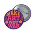 A round, glossy purple pinback button with the words "MAKE ART NOT WAR" in a groovy, retro 70s-style font. The word "MAKE" is in orange, "ART" is in a vibrant pink, and "NOT WAR" is in orange. The text is surrounded by small, stylized flower and star details. This psychedelic protest pin is a piece of activist merch with a strong metal back and safety pin clasp, perfect as an anti-war or social justice accessory for a jean jacket or backpack. The pin has a handmade, indie aesthetic.
