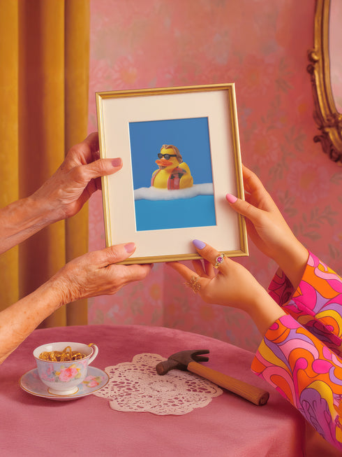 a woman holding a picture of a rubber ducky