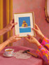 a woman holding a picture of a rubber ducky