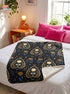 A rectangular velveteen minky blanket featuring a repeating dark academia pattern on a deep black background. The design includes gold and cream Ouija planchettes, each containing a blue all-seeing eye, a cream circle, and a light blue crescent moon framed by botanical leaves. Scattered between the planchettes are gold flowers with light blue stems, additional crescent moons, and small four-point stars. The reverse side of the blanket is made of a fluffy, textured off-white sherpa fleece.