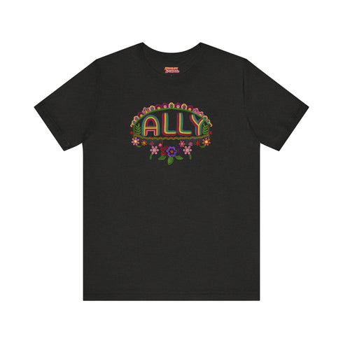 Black t-shirt featuring "ALLY" in gold letters protected by a rainbow arch and flanked by two sunflowers. LGBTQ+ pride ally shirt with colorful folk art-inspired design, available in cotton-poly blend, sizes S-3XL.