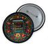 Round black pinback button with vibrant Mexican folk art-inspired embroidery design featuring red, yellow, blue and teal flowers surrounding a gold book spine with "Read Banned Books" text. Literary protest accessory with glossy finish and safety pin backing, available in 2" and 3" sizes.