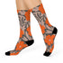 Colorful mid-calf crew socks featuring a bold orange hibiscus floral pattern layered over wavy zebra stripes in taupe and gray, with black heels and toes.