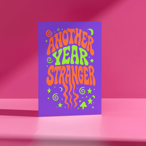 A colorful card with the text "Another Year Stranger" displayed prominently on it.