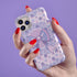 Coquette phone case featuring a pastel purple bow and pink floral lace background, dual-layer protection, UV protected, compatible with iPhone, Samsung Galaxy, and Google Pixel.
