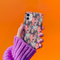 Stylish phone case with a colorful collage of iconic artists including Frida Kahlo, Warhol, Dali, and Keith Haring. Vibrant pop art design features stylized portraits on a dark background, perfect for art lovers.