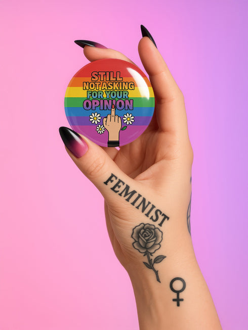 Round glossy pinback button measuring 2.25 inches with bold red graphic design on a black background. Text reads “Gay As Hell” above a red pentagram surrounded by flames, stars, roses, and candles. Made of tinplate with a safety pin back and a scratch-resistant mylar finish. The button features a high-gloss surface and is lightweight and durable, perfect for jackets, bags, or accessories.