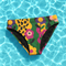 High-waisted bikini bottom with a bold retro floral print in green, yellow, pink, and black. Features cheeky fit and double-layered construction, floating on a turquoise pool background. The maximalist flower pattern and pop-art color palette give strong Y2K and festival vibes. Perfect for summer beach days, pool parties, and dopamine dressing.