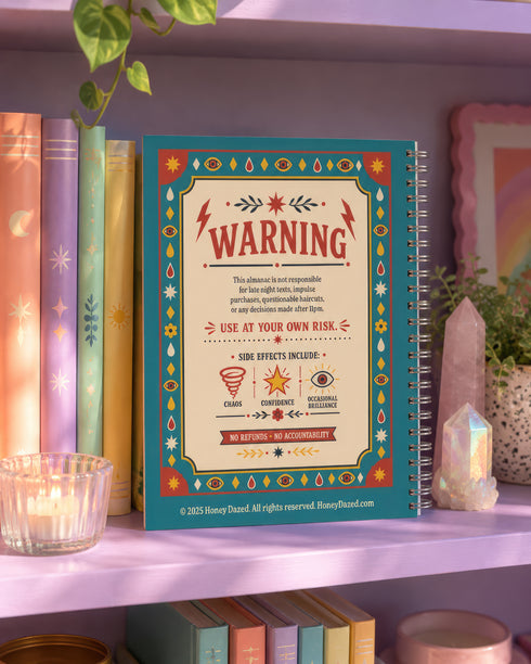 A spiral-bound hardcover planner featuring a retro-style teal cover with the text "An Almanac of Poor Decisions" in bold red and cream typography. The cover includes a grumpy cloud raining down lightning bolts, alongside stars, flowers, and vintage banners. The interior reveals crisp white pages with a 2026 to 2027 year-at-a-glance spread, plus clean, minimalist, completely undated monthly and weekly calendar grids with dedicated sections for writing daily to-do lists and random notes.