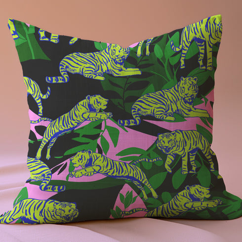 Square pillow cover featuring neon chartreuse tigers with cobalt blue stripes lounging among emerald green palm fronds on a black background with pink geometric accents.