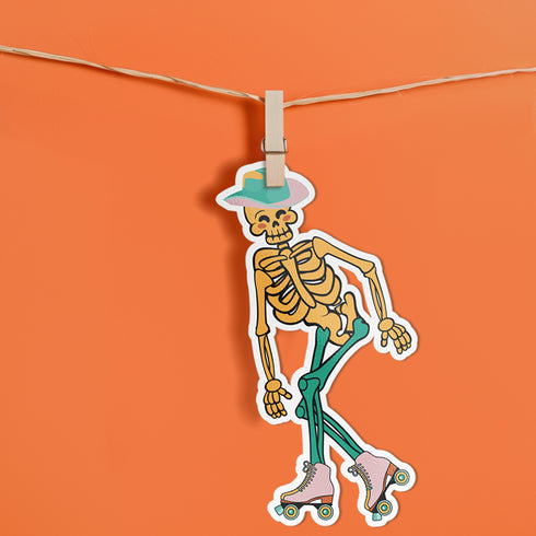A sticker featuring a whimsical skeleton dressed in a green cowboy hat, casually posed with one leg propped up. The skeleton sports a full grin and is adorned with vibrant teal and orange roller skates, adding a playful and surreal touch to the design.