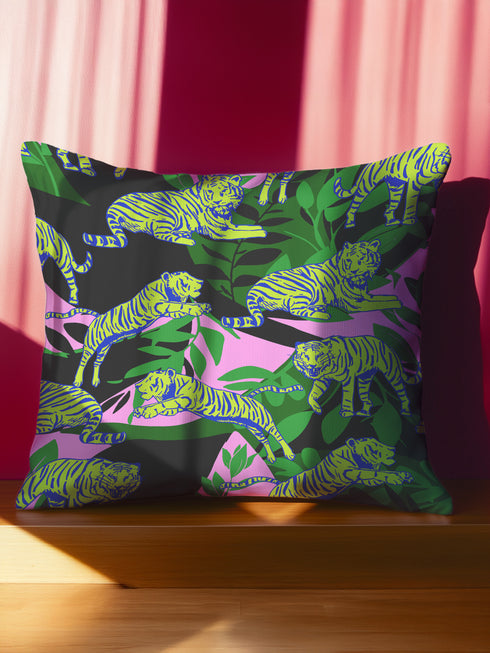 Square pillow cover featuring neon chartreuse tigers with cobalt blue stripes lounging among emerald green palm fronds on a black background with pink geometric accents.