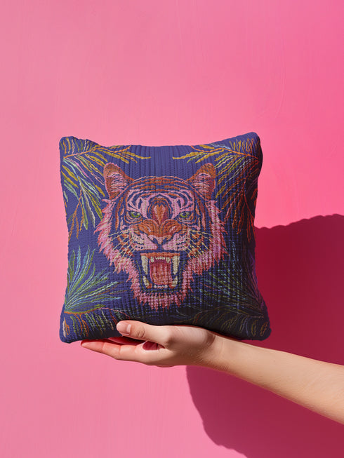 Square woven pillow featuring a fierce pink tiger with bared fangs against electric blue background surrounded by psychedelic jungle leaves. Textured tapestry design creates vibrant maximalist tiger decor perfect for gothic or eclectic home styling.