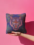 Square woven pillow featuring a fierce pink tiger with bared fangs against electric blue background surrounded by psychedelic jungle leaves. Textured tapestry design creates vibrant maximalist tiger decor perfect for gothic or eclectic home styling.