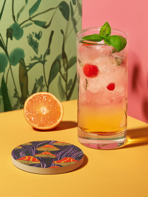 Round ceramic coaster featuring orange and yellow mushrooms with striped caps against a dark background with flowing purple lines in a psychedelic 70s style