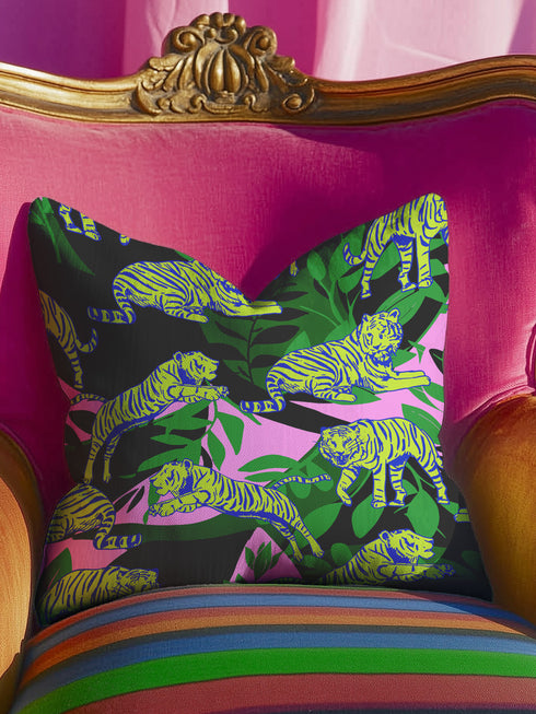 Square pillow cover featuring neon chartreuse tigers with cobalt blue stripes lounging among emerald green palm fronds on a black background with pink geometric accents.