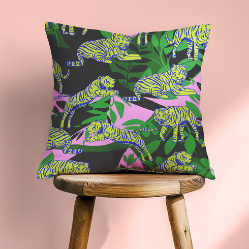 Square pillow cover featuring neon chartreuse tigers with cobalt blue stripes lounging among emerald green palm fronds on a black background with pink geometric accents.