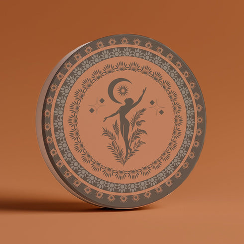 Round ceramic coaster featuring a silhouetted dancing figure reaching for a crescent moon, surrounded by concentric rings of stars and botanical patterns in terracotta and umber tones